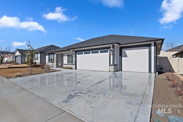 ranch-style home with stone siding, an attached garage, fence, and driveway