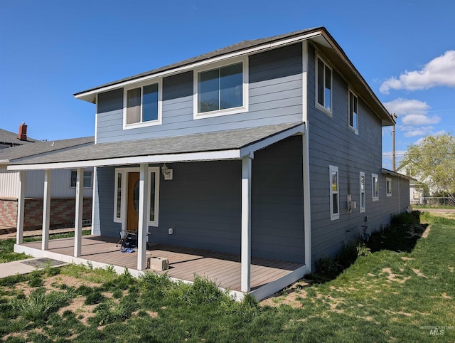 exterior space featuring a lawn and a shingled roof