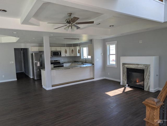 unfurnished living room with a ceiling fan, coffered ceiling, baseboards, dark wood-style floors, and a high end fireplace