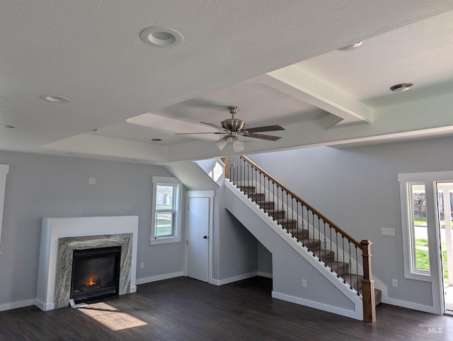 unfurnished living room with stairway, ceiling fan, baseboards, and dark wood-style floors