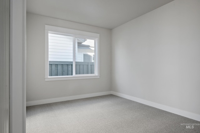 empty room with baseboards and carpet flooring