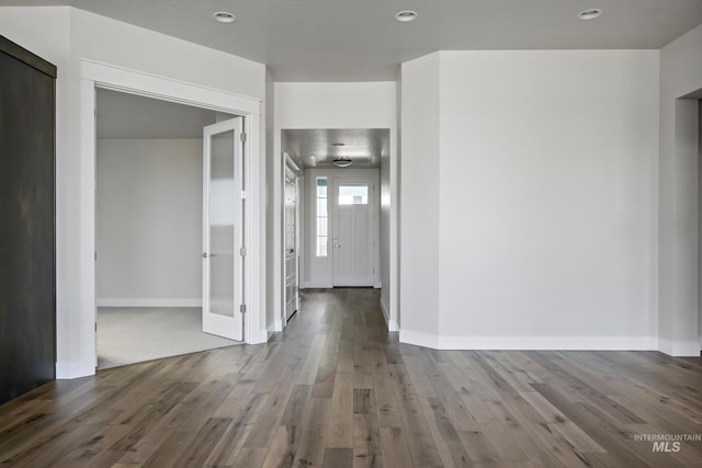 hall with hardwood / wood-style floors, baseboards, and recessed lighting
