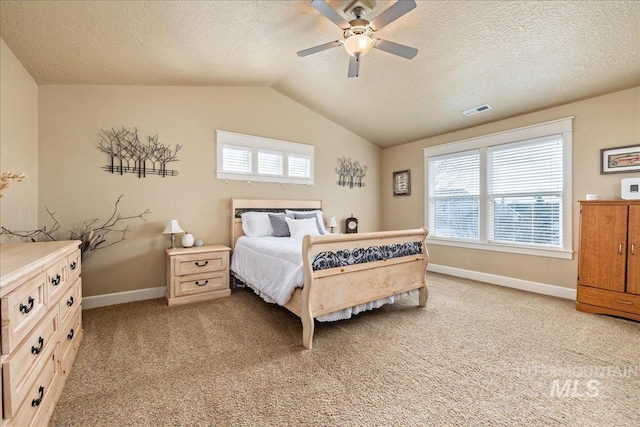 bedroom featuring a ceiling fan, visible vents, baseboards, lofted ceiling, and light colored carpet