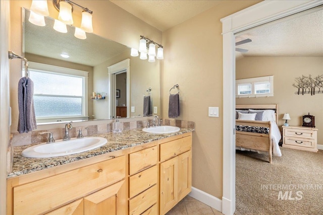 bathroom with a sink, connected bathroom, and a textured ceiling