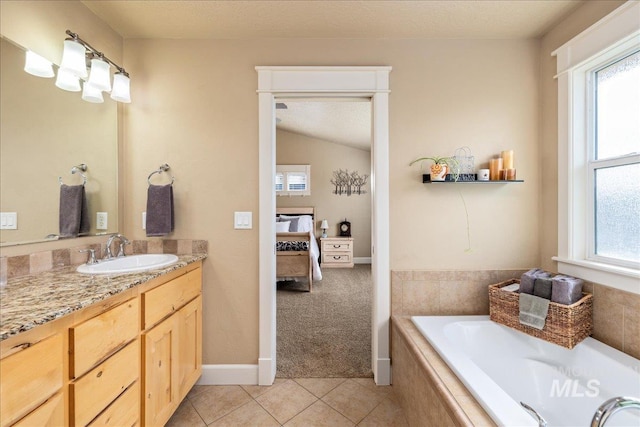 full bath featuring tile patterned flooring, a healthy amount of sunlight, vanity, and ensuite bathroom