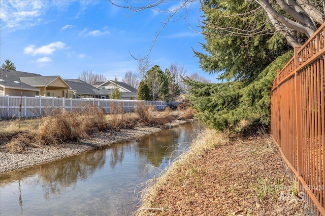 property view of water featuring fence