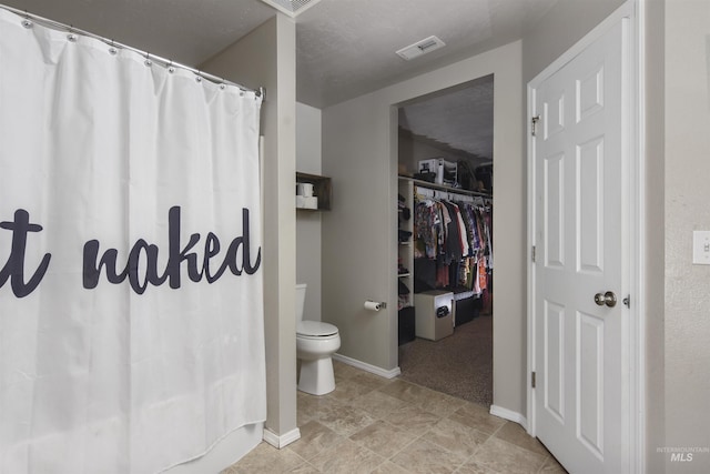 bathroom featuring a shower with curtain and toilet