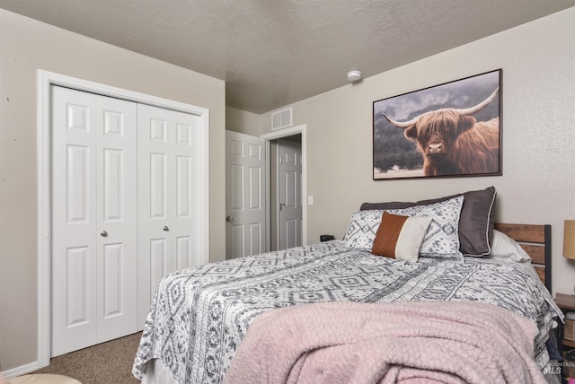 carpeted bedroom with a closet and a textured ceiling