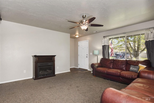 living room featuring ceiling fan, a textured ceiling, and dark colored carpet