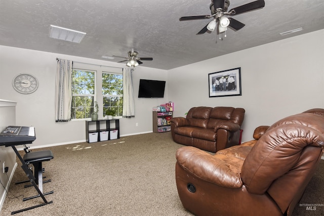 carpeted living room featuring ceiling fan and a textured ceiling