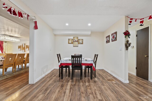 dining space featuring dark hardwood / wood-style flooring and a textured ceiling