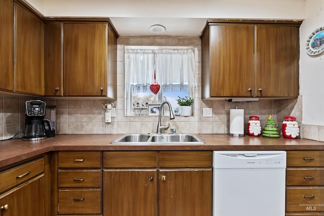 kitchen featuring decorative backsplash, dishwasher, and sink