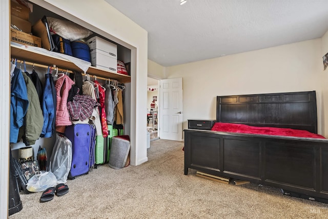 carpeted bedroom featuring a textured ceiling and a closet