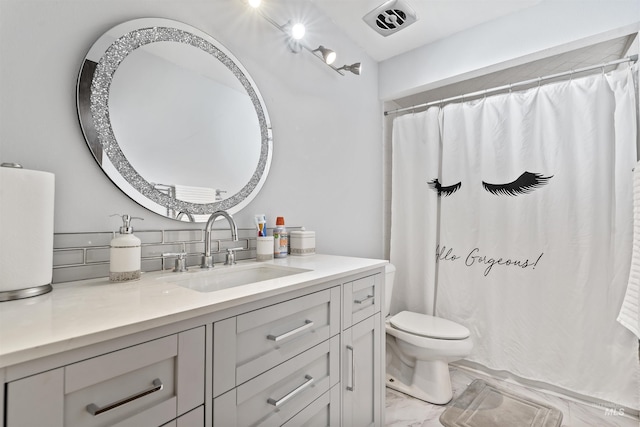 bathroom with vanity, curtained shower, and toilet