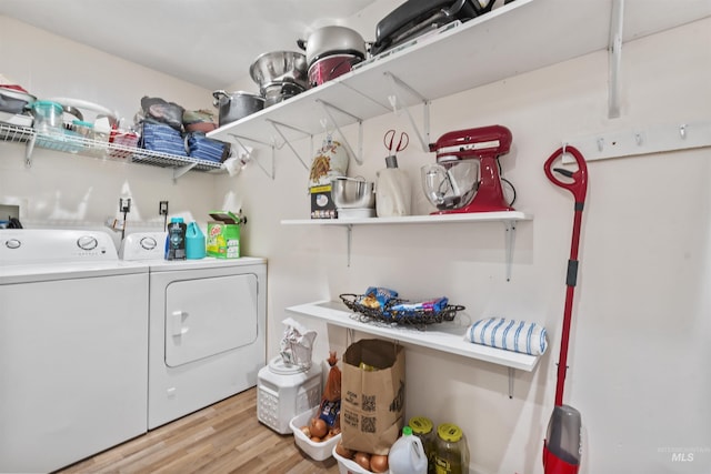 clothes washing area featuring separate washer and dryer and light hardwood / wood-style flooring