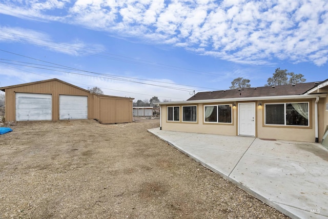 rear view of property featuring an outbuilding and a garage