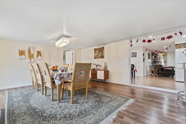 dining area with hardwood / wood-style floors and a notable chandelier