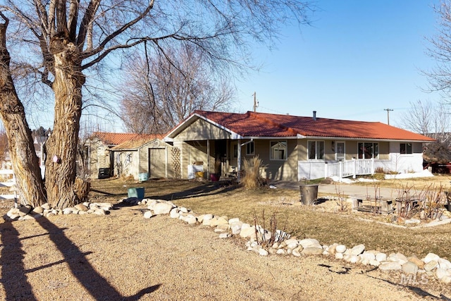 ranch-style house with an outbuilding, a garage, and covered porch