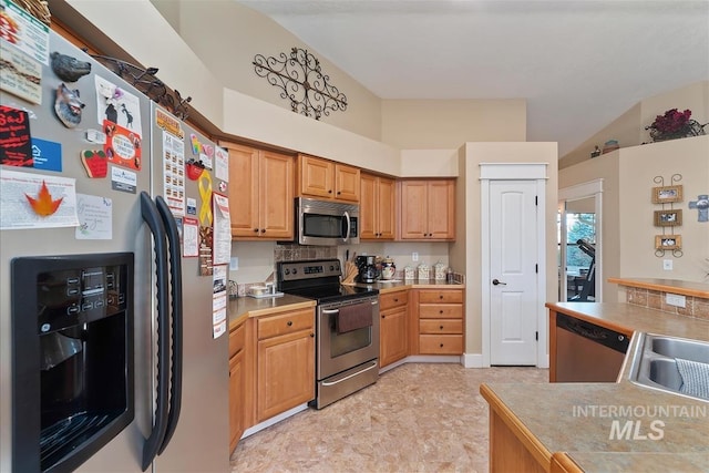 kitchen featuring light countertops, vaulted ceiling, and stainless steel appliances