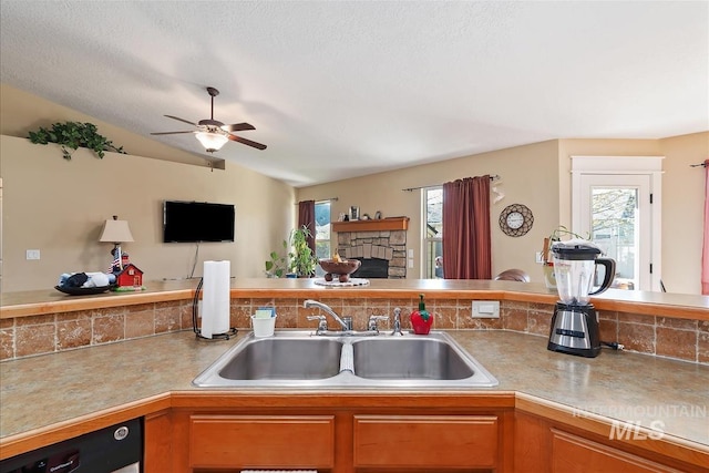kitchen featuring decorative backsplash, open floor plan, a sink, and ceiling fan