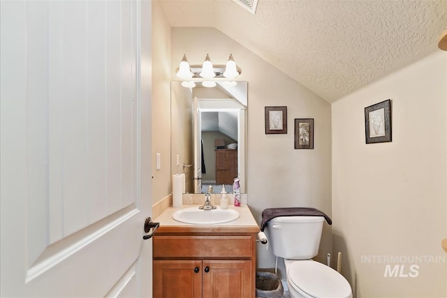 half bath featuring toilet, a textured ceiling, vanity, lofted ceiling, and visible vents