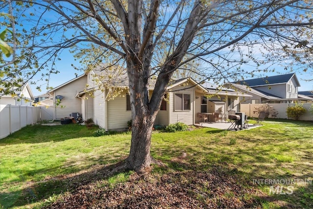 back of house featuring a yard, a patio, and a fenced backyard