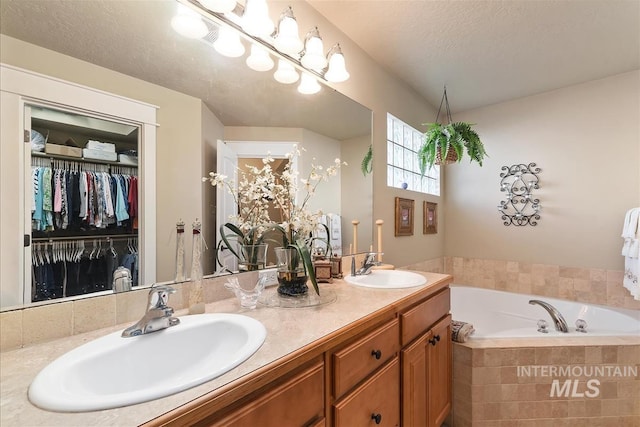 bathroom featuring a bath, a walk in closet, a sink, and double vanity