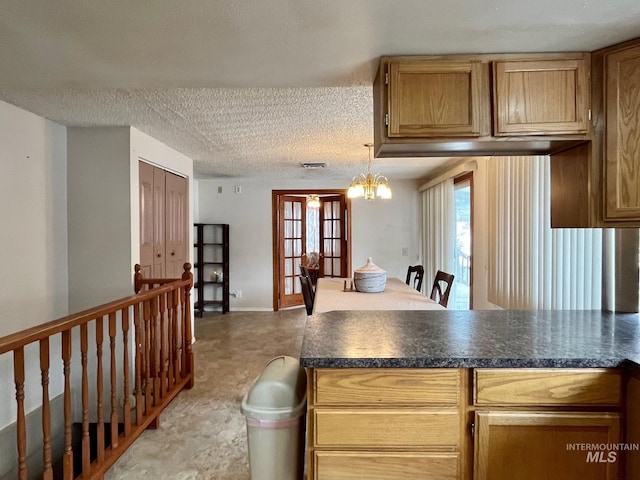 kitchen featuring a chandelier, a textured ceiling, and french doors