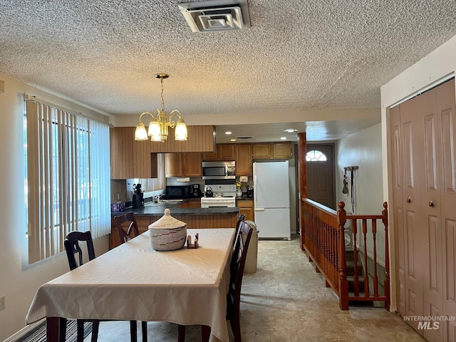 dining room featuring an inviting chandelier and a textured ceiling