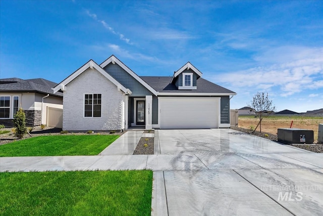 view of front of house with a garage, brick siding, concrete driveway, and a front yard