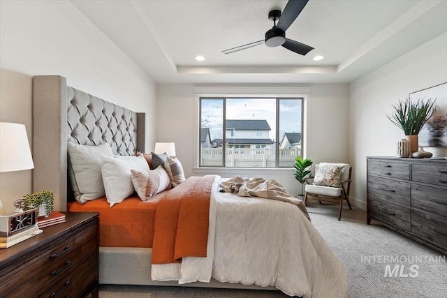 carpeted bedroom with a ceiling fan, a tray ceiling, and recessed lighting