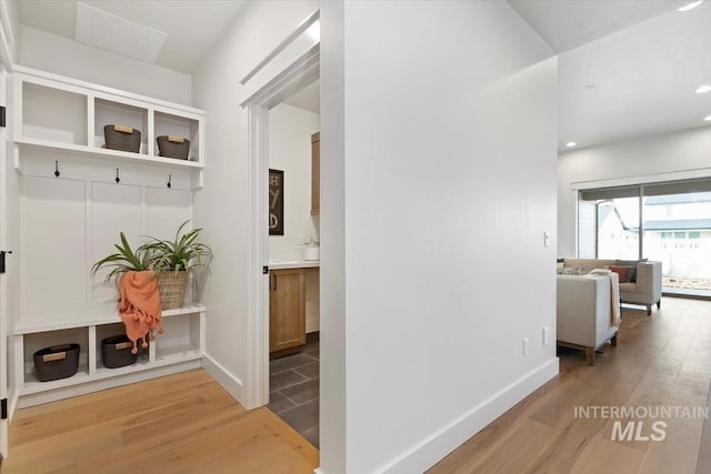 hall featuring recessed lighting, baseboards, and wood finished floors