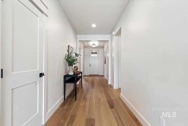 hall with light wood-type flooring and baseboards