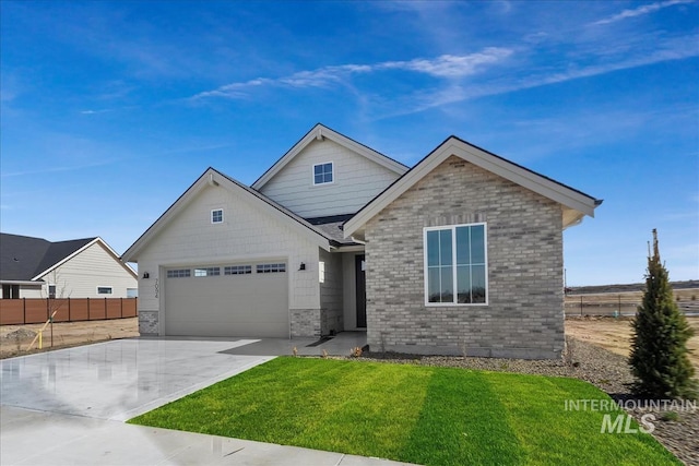 view of front of home featuring driveway, fence, a front yard, an attached garage, and brick siding