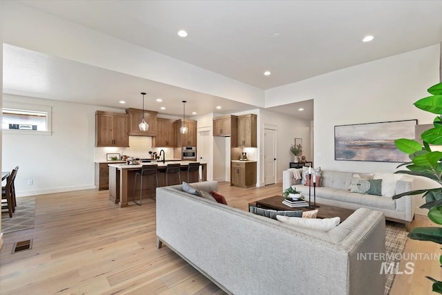 living room featuring recessed lighting, light wood-style floors, visible vents, and baseboards