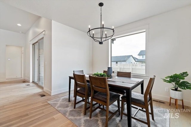 dining room with visible vents, baseboards, light wood-style flooring, and a chandelier