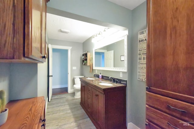 bathroom featuring hardwood / wood-style flooring, vanity, and toilet