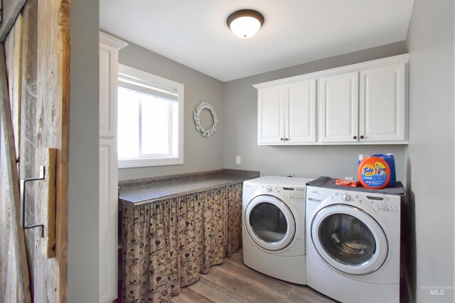 laundry room with cabinets, hardwood / wood-style floors, and independent washer and dryer