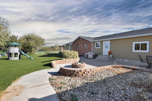view of yard with a playground, a patio area, and a fire pit