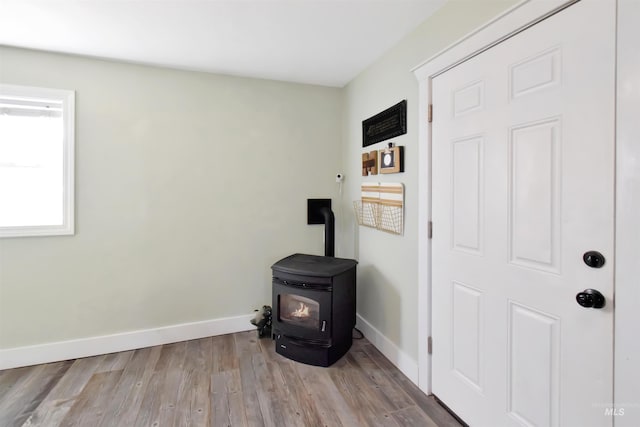 interior details with a wood stove and hardwood / wood-style floors
