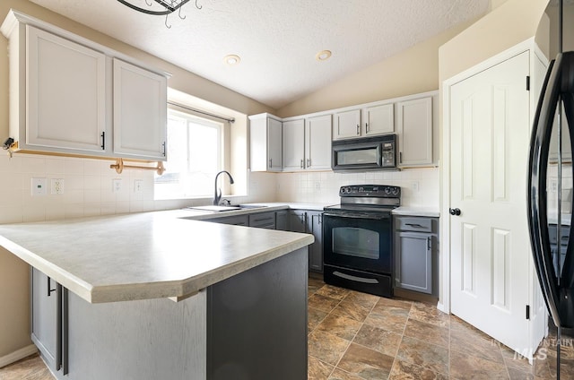 511 Bitterbrush Ave, Nampa, ID 83686 - kitchen featuring black appliances, a sink, a peninsula, vaulted ceiling, and a textured ceiling