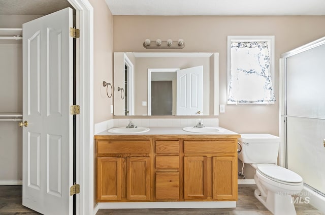 511 Bitterbrush Ave, Nampa, ID 83686 - bathroom featuring a stall shower, double vanity, toilet, and baseboards