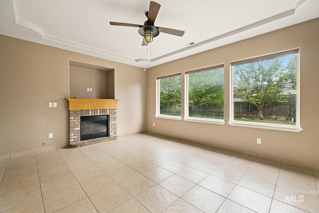 511 Bitterbrush Ave, Nampa, ID 83686 - unfurnished living room with a raised ceiling, a brick fireplace, tile patterned flooring, and a ceiling fan