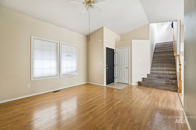 511 Bitterbrush Ave, Nampa, ID 83686 - unfurnished living room featuring wood finished floors, stairs, lofted ceiling, ceiling fan, and baseboards