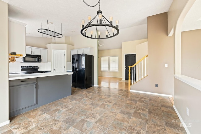 511 Bitterbrush Ave, Nampa, ID 83686 - kitchen with black appliances, a chandelier, baseboards, light stone finish flooring, and light countertops