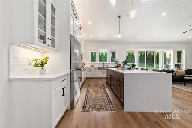 1889 W Winter Camp Ct, Boise, ID 83703 - kitchen with a sink, open floor plan, backsplash, white cabinets, and glass insert cabinets