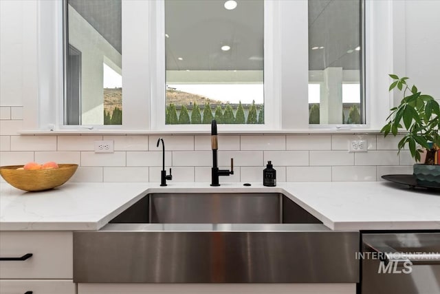 1889 W Winter Camp Ct, Boise, ID 83703 - kitchen view of a sink, stainless steel dishwasher, backsplash, and light stone countertops