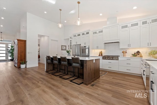 1889 W Winter Camp Ct, Boise, ID 83703 - kitchen featuring appliances with stainless steel finishes, a center island, white cabinetry, tasteful backsplash, and recessed lighting