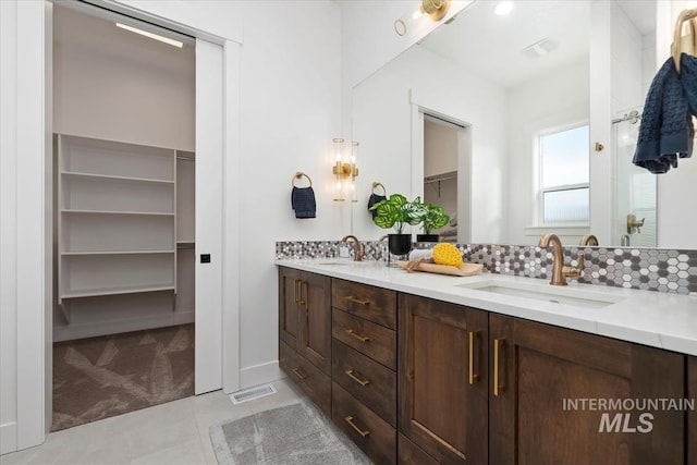 1889 W Winter Camp Ct, Boise, ID 83703 - full bathroom featuring double vanity, a spacious closet, tile patterned floors, and decorative backsplash
