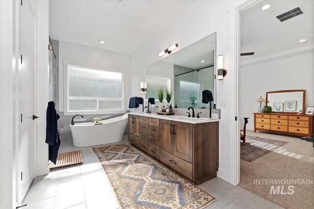 1889 W Winter Camp Ct, Boise, ID 83703 - bathroom with double vanity, a freestanding bath, a shower stall, recessed lighting, and tile patterned flooring
